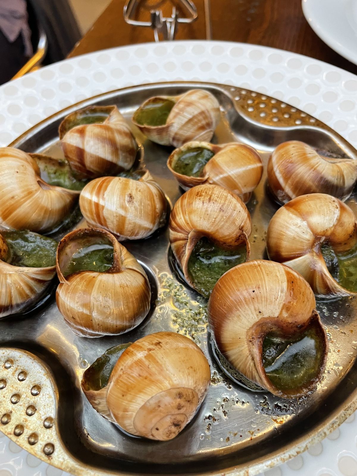 Escargots — snails in herb butter on an ornate silver platter